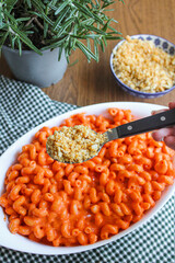 Tomato pasta Cavatappi bake in the making. Preparing oven-baked pasta with red peppers and breadcrumbs. 