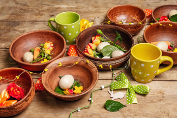 Easter ceramic bowls with eggs, bunnies, and fresh roses on a vintage table