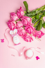 Traditional Easter symbols concept with cute rabbit from an egg, festive decor and gentle roses
