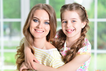 Close-up portrait of a charming little girl with mom at home