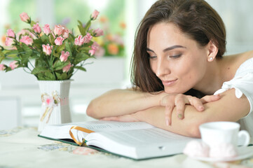 Young attractive woman with book and  cup of coffee