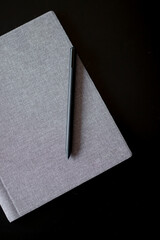 Notebook and pen on the black table close up