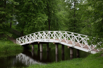 White wooden bridge in the old park in the village of Mikhailovskoye, Pskov region, Russia
