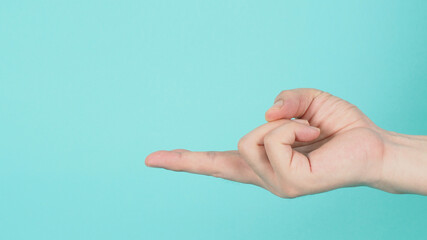 Empty Hand holding or catch nothing guesture on green and blue or mint background.