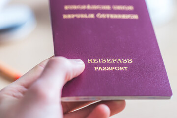 Passport vacation concept: Close up of fingers holding a passport, arrival or departure, “Reisepass Passport”