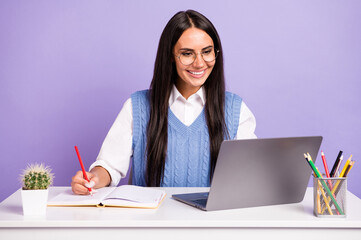 Portrait of attractive focused cheerful woman studing writing exercise task diary planner isolated...