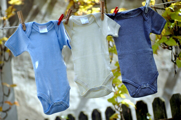 Babybodys hängen zum trocknen an einer Wäscheleine