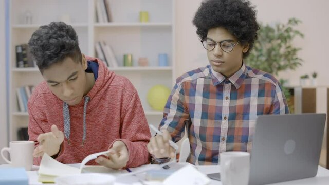 Two busy students having difficulties with studying at home, distance learning