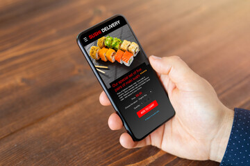 Person ordering sushi on mobile phone for home delivery