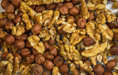 Assorted peeled walnuts and hazelnuts on a light background with a bokeh effect