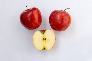 Two red apples with a half isolated on a white background Top view.