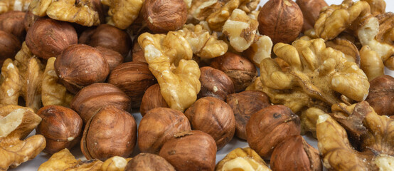 Assorted peeled walnuts and hazelnuts on a light background with a bokeh effect
