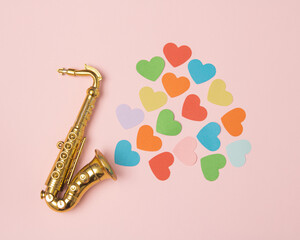 Golden saxophone from which hearts of different colors come out
