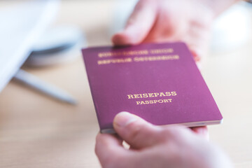 Passport vacation concept: Close up of fingers holding a passport, arrival or departure, &ldquo;Reisepass Passport&rdquo;