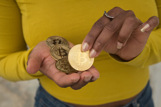 Detail Of African American Woman´s Hands In Yellow T-shirt Counting Cryptocurriencies.