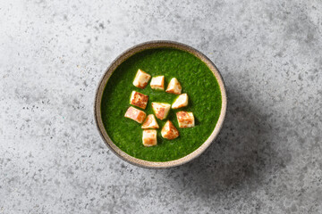 Palak Paneer made of spinach and paneer cheese isolated on grey stone background. Indian cuisine. View from above.