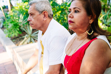 Senior couple would be sitting on park bench enjoying retirement