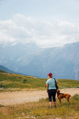 une femme promène son chien. Une femme randonne avec son chien dans la montagne. Une promenade avec son chien. Sortir le chien. Une randonnée avec un chien.