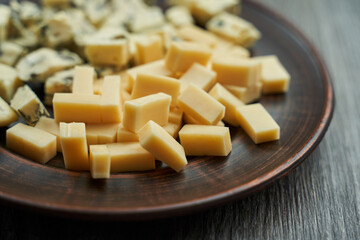 diced cheese on a plate. one with blue mold second yellow