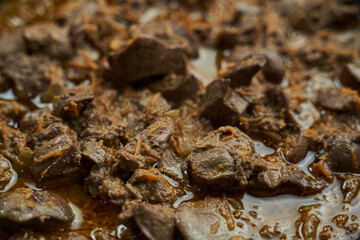 fried chicken liver with onions and carrots close-up