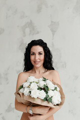 naked body of a girl covered with a large bouquet of flowers