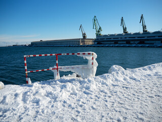 The port of Gdynia in winter on a sunny ice cold day. Snow and ice on the wharf with a view of the...