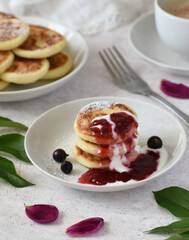 Сheese pancakes with raspberry jam on a white table