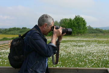 man photographing flowers
