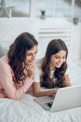 Joyful woman and girl in front of laptop