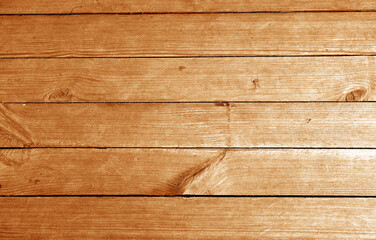 Wall made of uncutted weathered wood boards in orange tone.