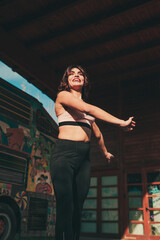 young sporty girl performs a dance step in an outdoor place