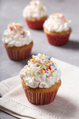 Tasty party cupcakes on the table. Cupcakes with whipped cream.