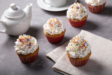 Tasty party cupcakes on the table. Cupcakes with whipped cream.