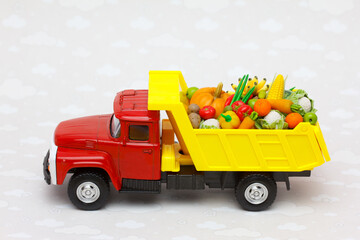 peasant farm vegetables shipping. A  toy truck delivering fresh fruits and vegetables 