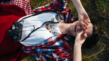 Fototapeta na wymiar girl lies with a camera in the grass