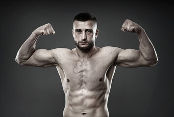 Fototapeta na wymiar Athletic fighter posing on gray