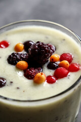 Yogurt with berry and kiwi in a glass. Fruit and berry smoothie. Milkshake with kiwi, raspberry, blueberry and banana Healthy food. Close up.