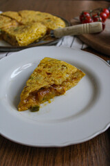 Tortilla pincho. Plated Spanish potato omelette pintxo on a set table. Serving slice of a tapa. 