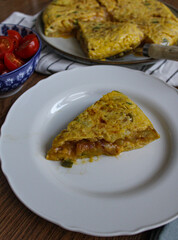 Tortilla pincho. Plated Spanish potato omelette pintxo on a set table. Serving slice of a tapa. 