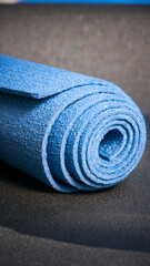 Esterilla de yoga azul enrollada sobre esterilla negra