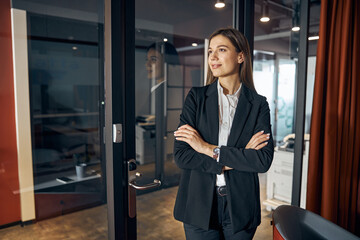 Dreamy female employee in business attire looking away