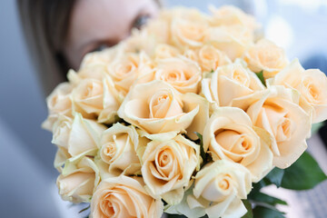 Woman holding large beautiful bouquet of white roses closeup