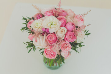 Beautiful pink roses in a glass jar on white background