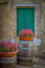 Fototapeta na wymiar Classic Italian scene of wine barrels and green window shutters