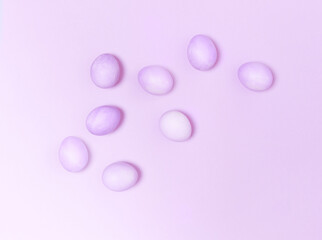 Creatively painted eggs in pastel colors on purple background.Happy Easter concept. Flat lay.
