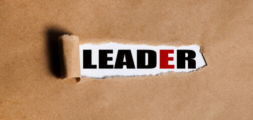 leader. text on white paper over torn paper background.