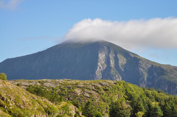 Fototapeta premium White cloud on top of the mountain in Helgeland archipelago in the Norwegian sea 