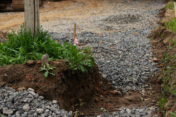 excavated road. repair of the street in the city with road equipment. laying of new asphalt and replacement of communications