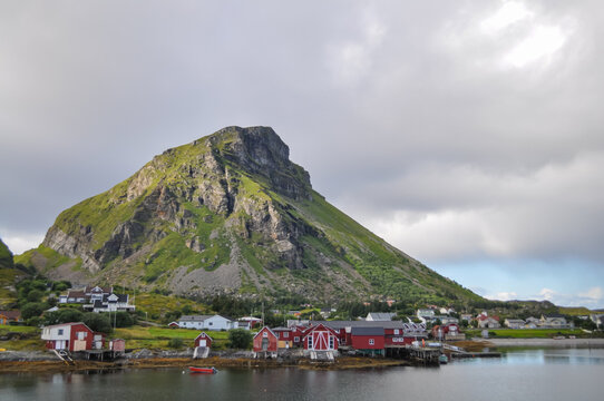 View from ferry to the Lovund island and harbor in Helgeland archipelago on sunny summer morning. White clouds over the blue sea