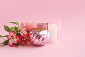 Composition with candles and flowers on color background